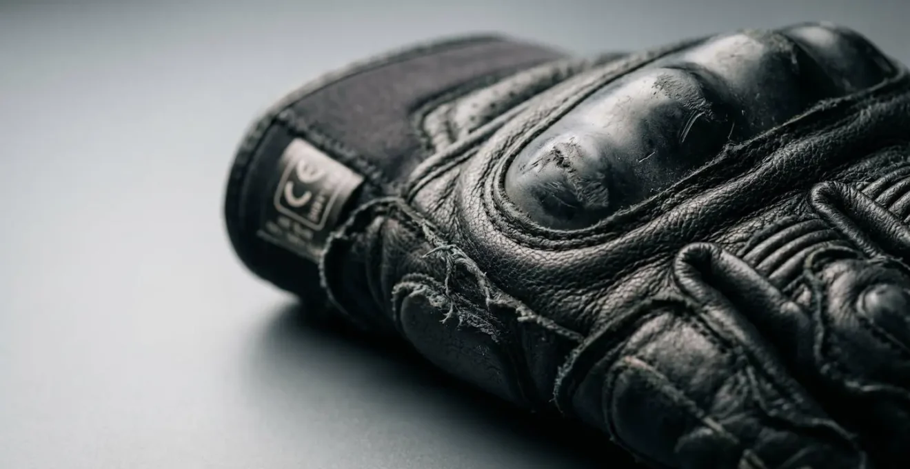 Gros plan sur des gants de moto certifiés CE avec étiquette de protection visible, symbole de sécurité routière obligatoire