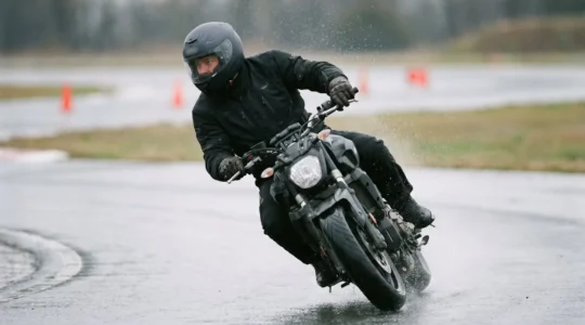 Motard en équipement complet lors d'un stage de perfectionnement sur piste mouillée pour améliorer sa sécurité et réduire son assurance
