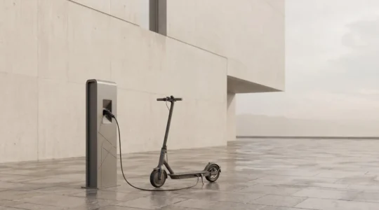 Scooter électrique branché sur une borne de recharge publique en milieu urbain