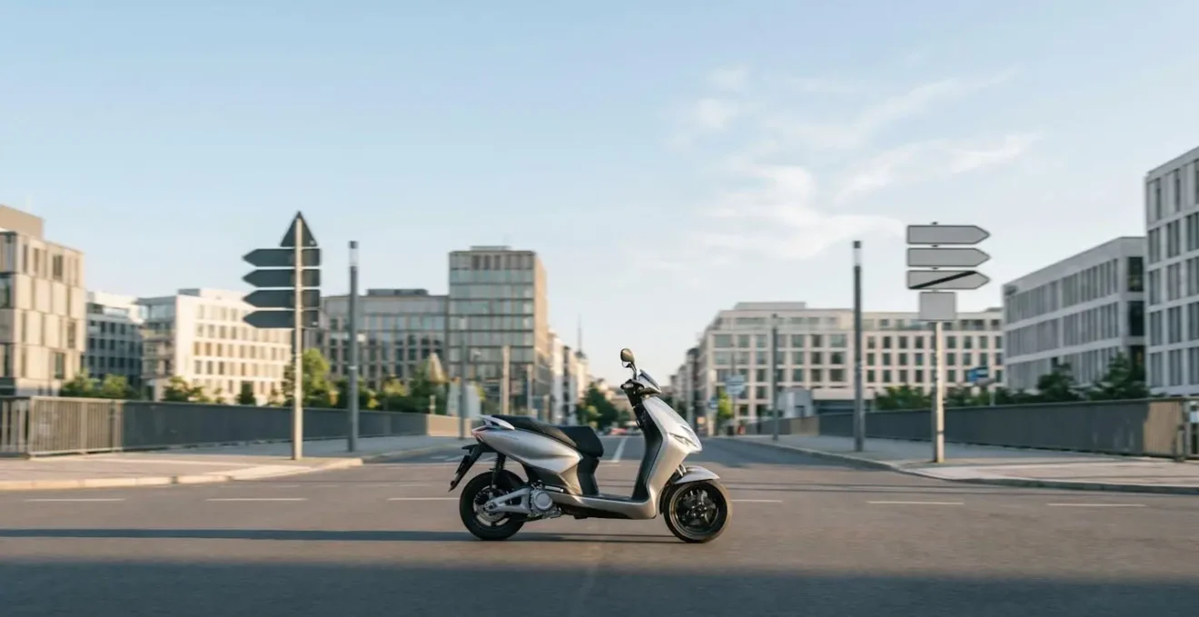 Scooter trois-roues hybride en circulation dans une zone urbaine moderne